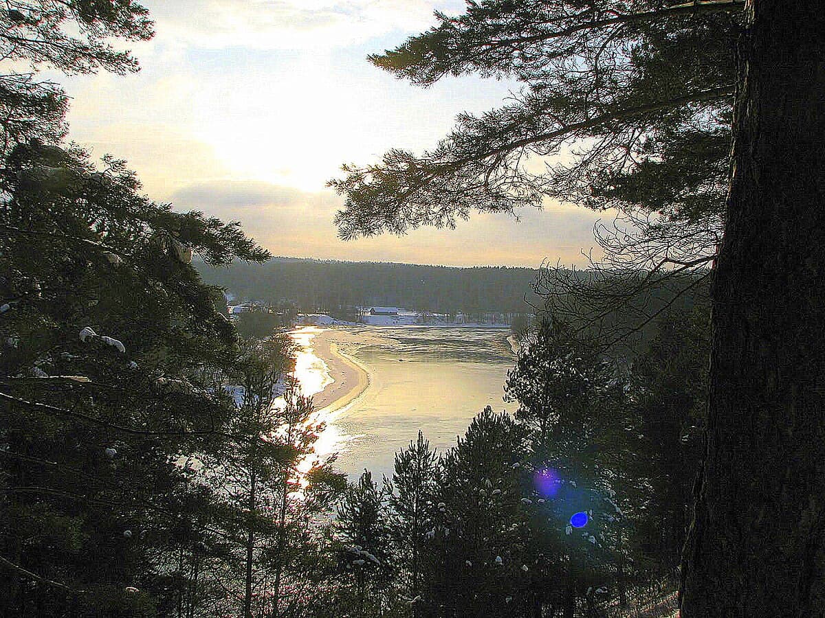 Five grass-covered hill forts of Kernavė rising above the Neris River valley