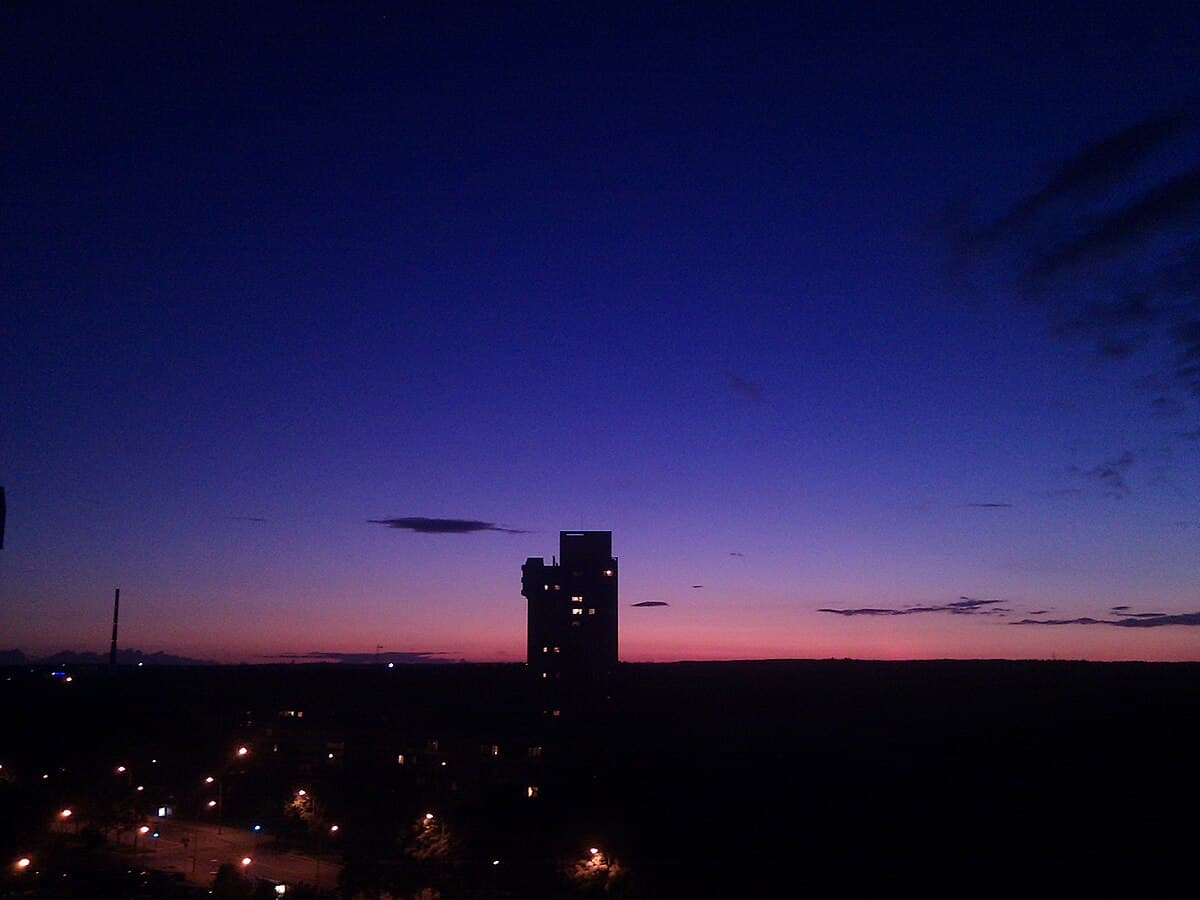 Overgrown concrete facade of the abandoned Lazdynai concert hall