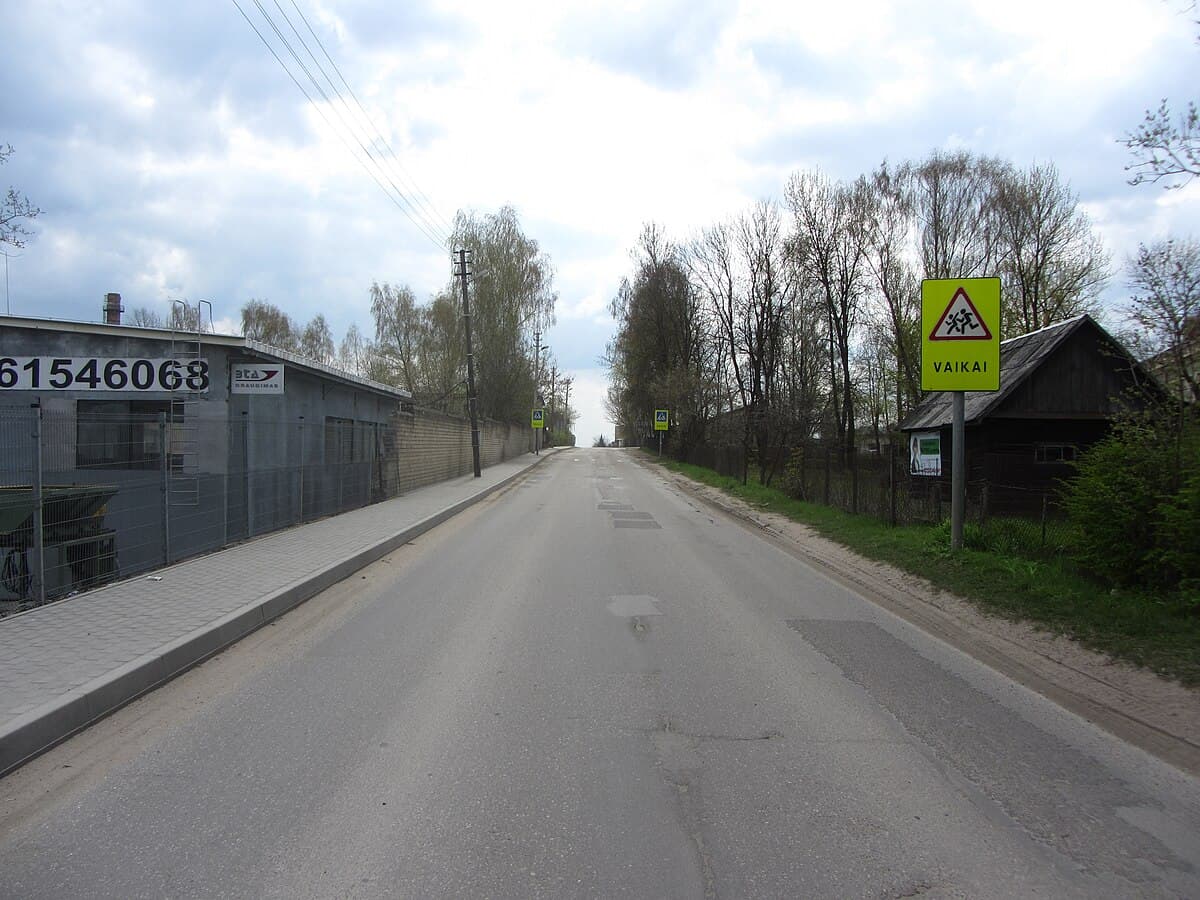 Crumbling neogothic facade of Lentvaris Manor surrounded by overgrown park