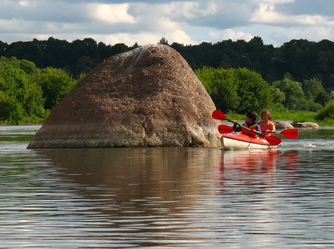Water cascading over moss-covered rocks at Naujoji Reva waterfall